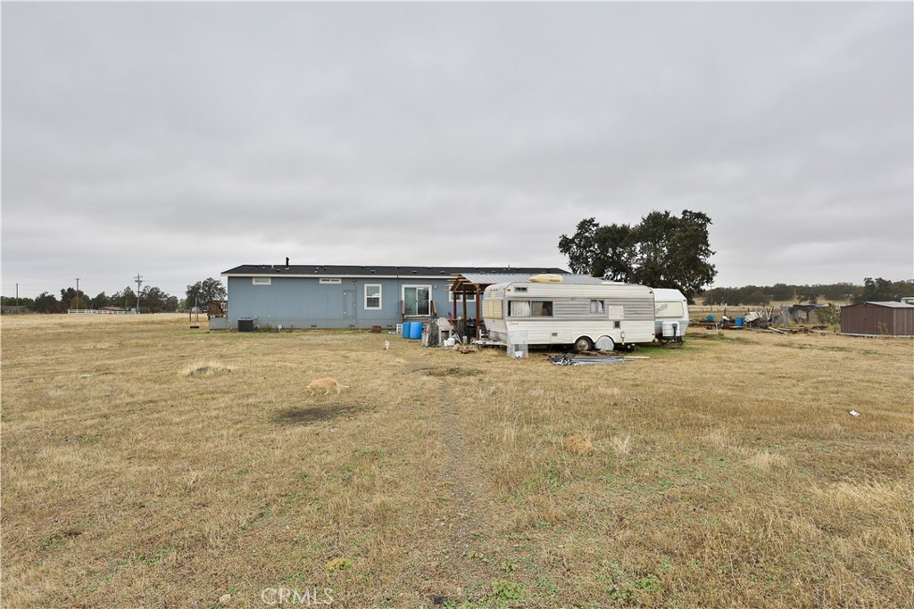 4210 Osborn Road Flournoy, CA 96021 - Photo 49 of 50 a white house that has a big tree and a yard