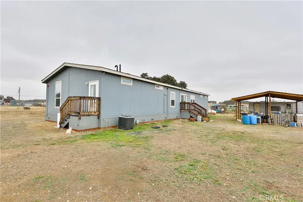 a view of a house with backyard and sitting area