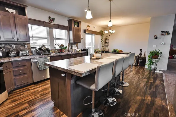 a large kitchen with cabinets a sink a counter space and stainless steel appliances