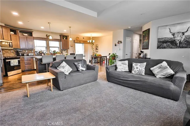 a living room with furniture wooden floor and a large window