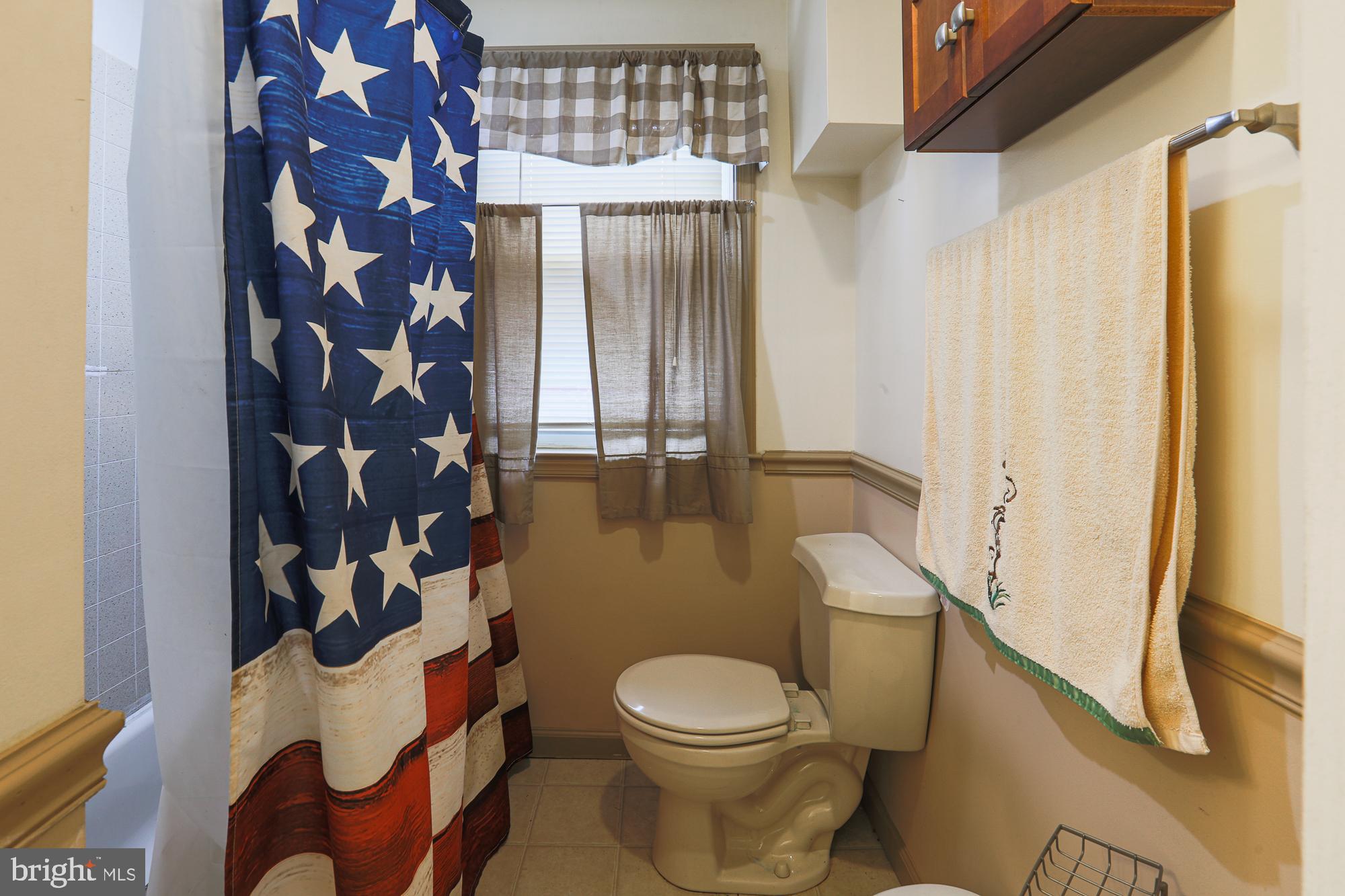 1225 Neighbors Avenue Rosedale, MD 21237 - Photo 22 of 33 a white toilet sitting next to a shower curtain