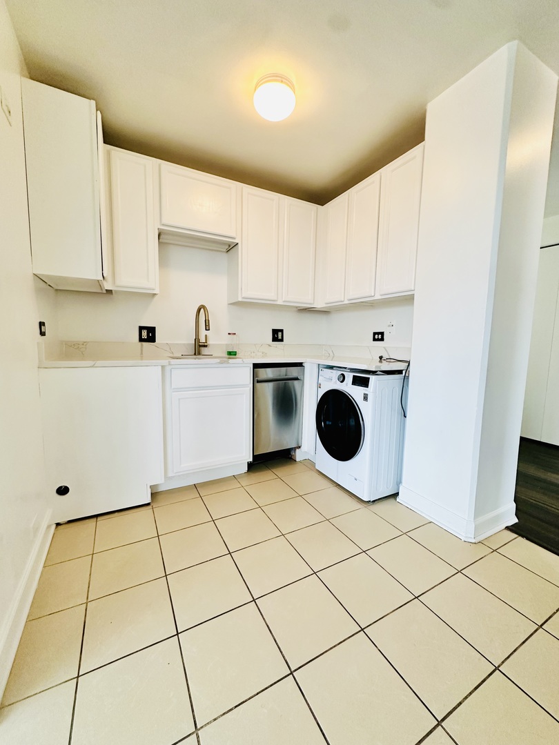 345 East Eastgate Place, Unit 602 Chicago, IL 60616 - Photo 5 of 13 a kitchen with a sink a stove and white cabinets