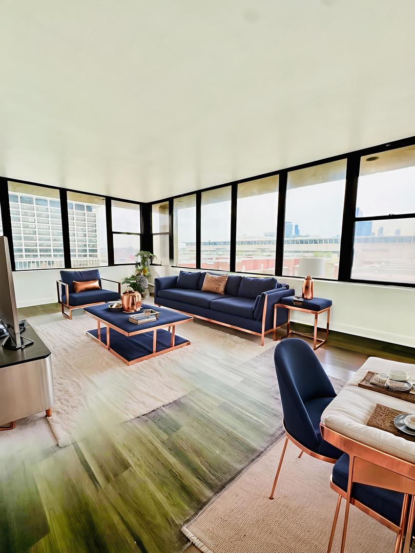 345 East Eastgate Place, Unit 602 Chicago, IL 60616 - Photo 8 of 13 a living room with furniture and a floor to ceiling window