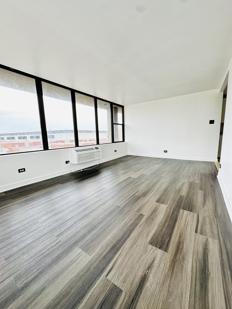 345 East Eastgate Place, Unit 602 Chicago, IL 60616 - Photo 9 of 13 a view of an empty room with window and wooden floor