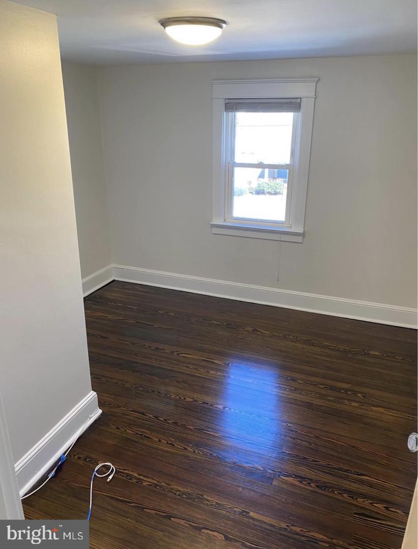 20 Reese Avenue, Unit 2 Newtown Square, PA 19073 - Photo 5 of 7 a view of an empty room with wooden floor and a window