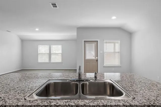 a kitchen that has a sink and granite countertops