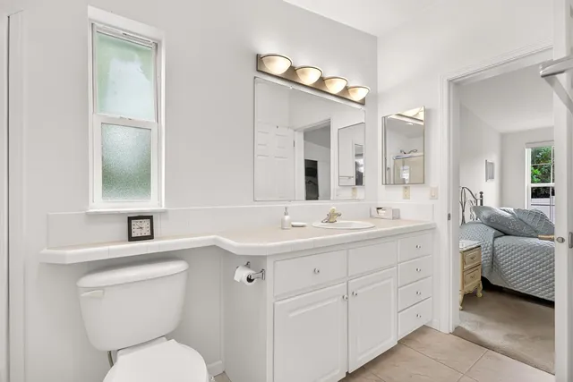 a bathroom with a toilet sink and mirror