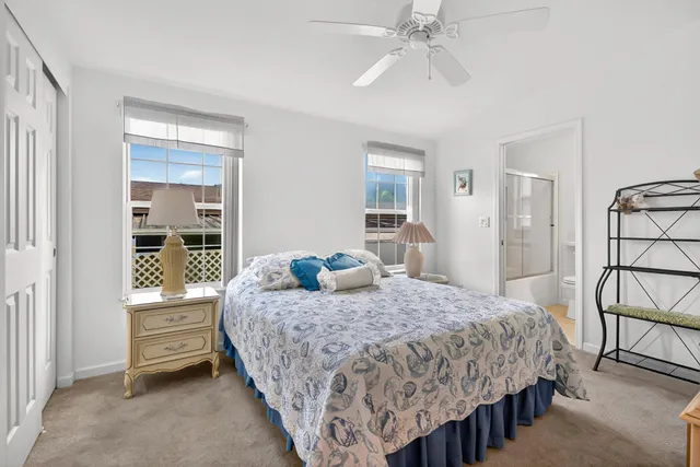 a bedroom with a bed a dresser and next to a window