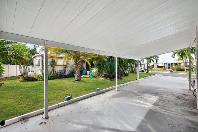 a view of a house with a big yard and palm trees
