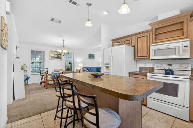 a kitchen with a table chairs refrigerator and cabinets