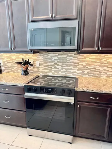 a kitchen with granite countertop cabinets stove and microwave