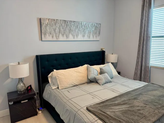 a bedroom with a bed and a night stand next to it