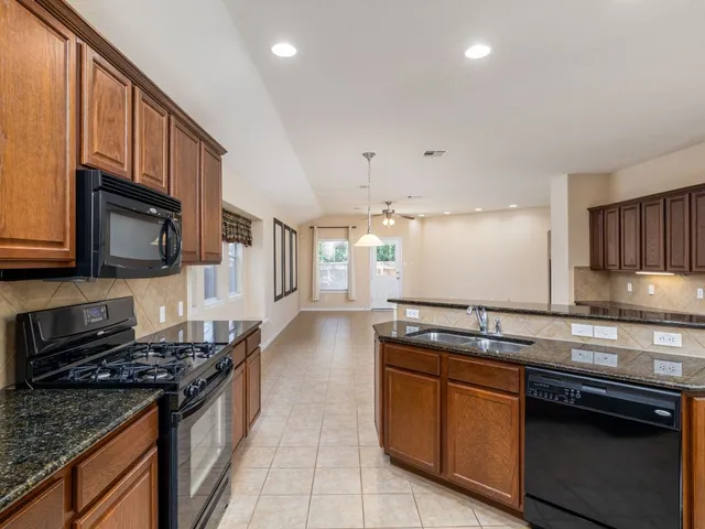 a kitchen with stainless steel appliances granite countertop a stove and a sink