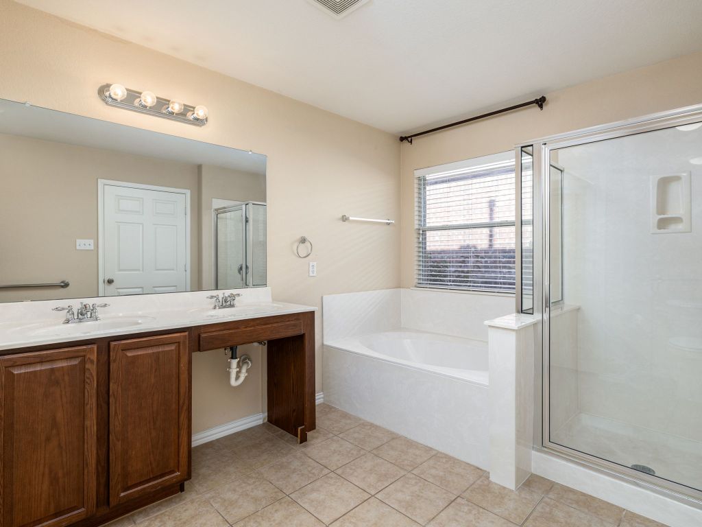 2005 Granite Springs Road Leander, TX 78641 - Photo 16 of 30 a spacious bathroom with a bathtub a double vanity sink and mirror