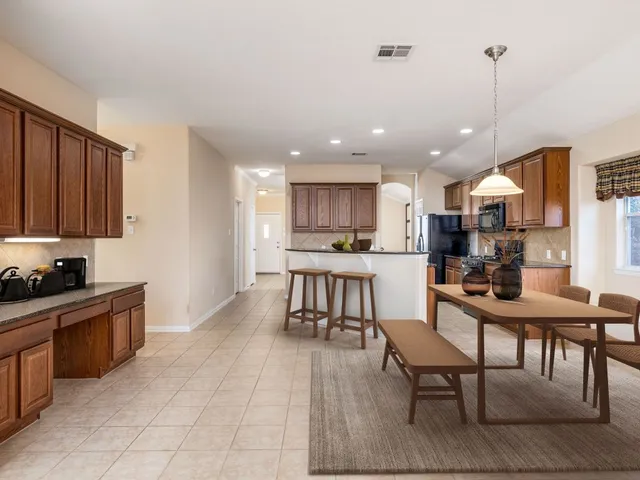 a kitchen with kitchen island granite countertop wooden cabinets and a refrigerator