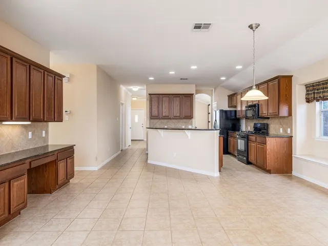 a large kitchen with cabinets and stainless steel appliances