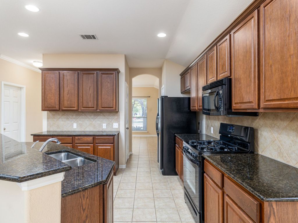 2005 Granite Springs Road Leander, TX 78641 - Photo 10 of 30 a kitchen with stainless steel appliances granite countertop a sink stove and refrigerator