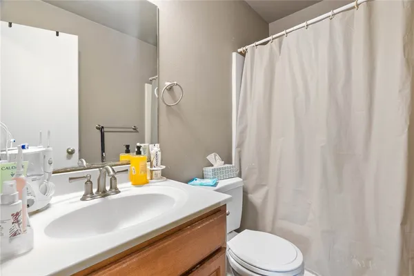 a bathroom with a sink vanity mirror and toilet