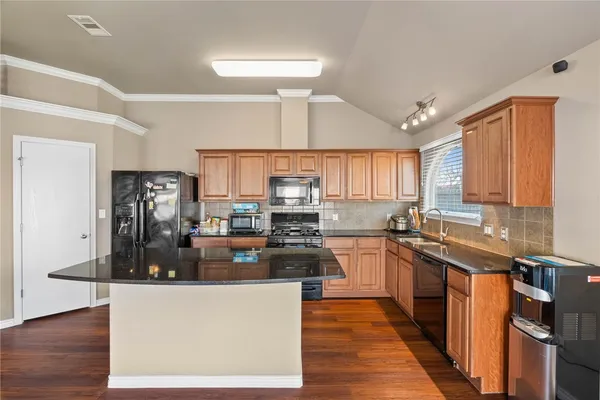 a kitchen with granite countertop a stove and cabinets