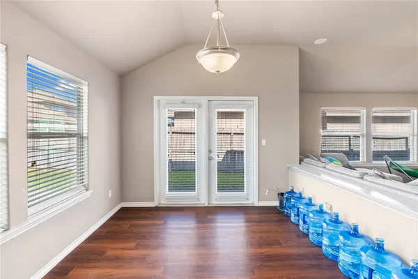 a view of an empty room with window and wooden floor