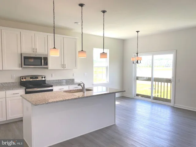 a kitchen with stainless steel appliances granite countertop a sink a window and a kitchen view