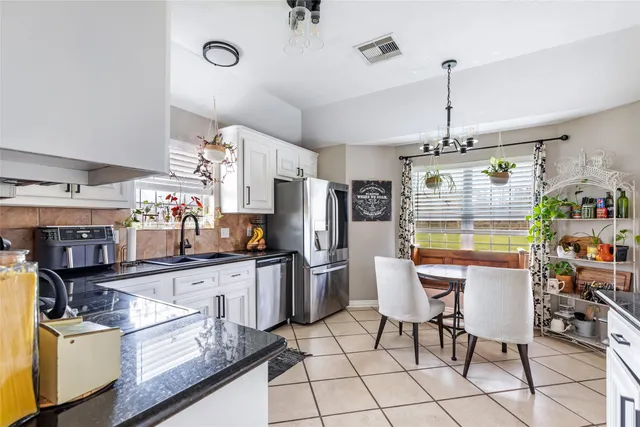 a kitchen with stainless steel appliances granite countertop a sink and a refrigerator