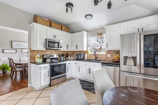 a kitchen with stainless steel appliances a stove refrigerator sink and cabinets