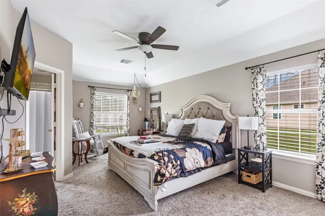 a bedroom with a bed a window and a flat screen television