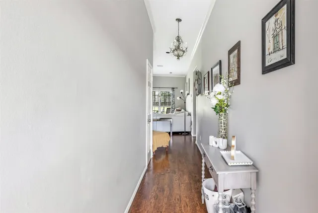 a view of a hallway with furniture and wooden floor