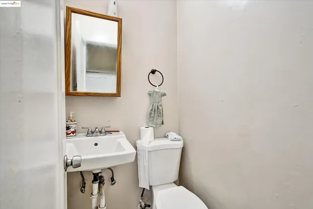 a bathroom with a toilet sink vanity and mirror