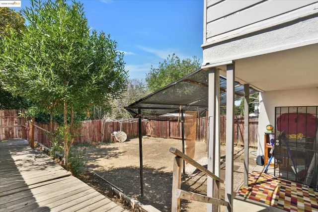 a patio with table and chairs and potted plants