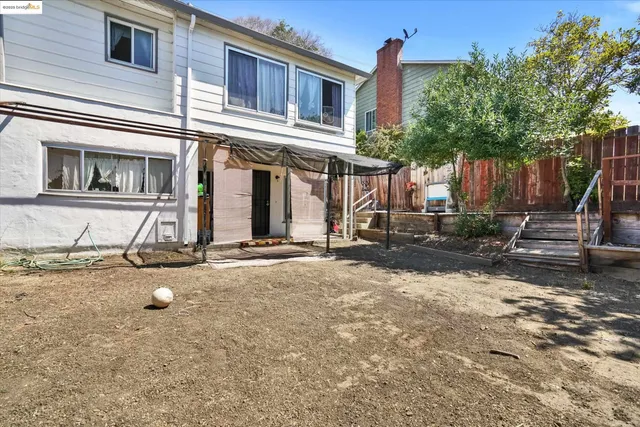a view of a house with backyard and sitting area