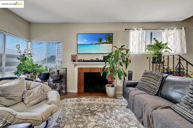 a living room with furniture a potted plant and a fireplace