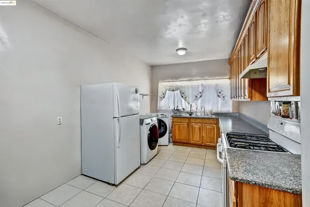 a kitchen with stainless steel appliances granite countertop a refrigerator and a stove