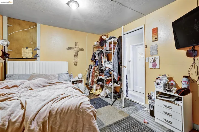 a bedroom with a bed and a flat tv screen on the dresser
