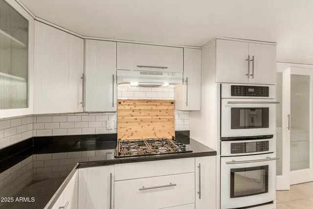 a kitchen with granite countertop a stove and a microwave