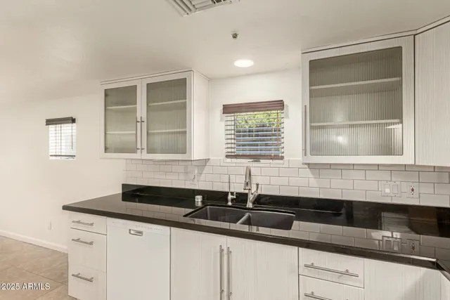 a bathroom with granite countertop a sink and a mirror