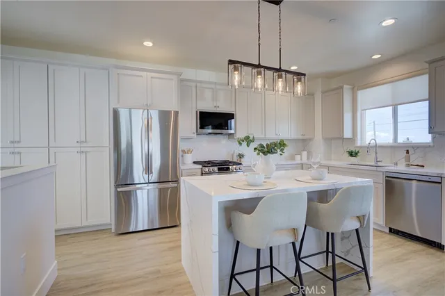 a kitchen with kitchen island white cabinets and stainless steel appliances