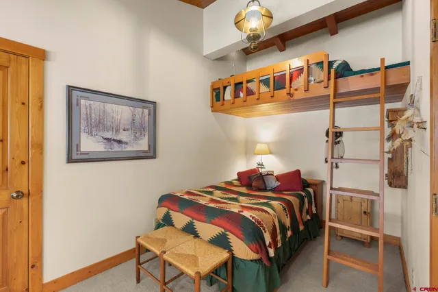 a bedroom with a bed and a lamp on the wall