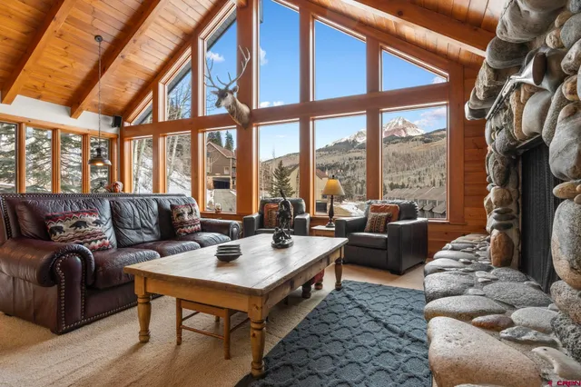 a living room with furniture a table and a large window