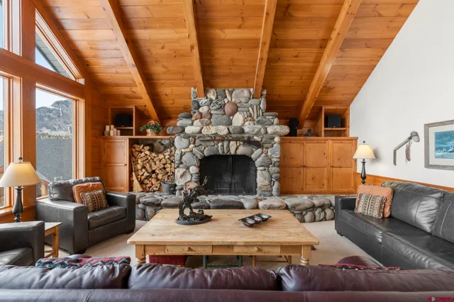 a living room with furniture a fireplace a large window and a fireplace