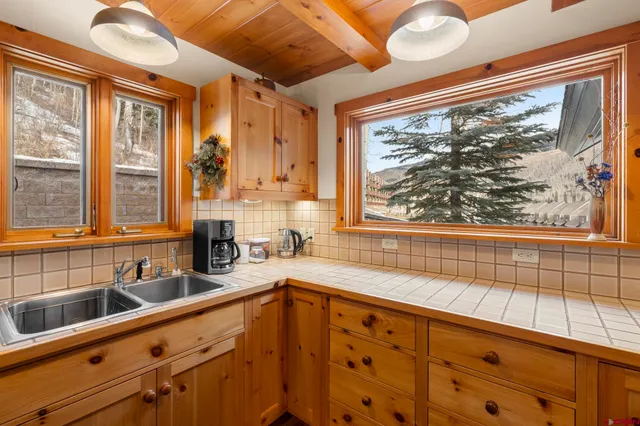 a kitchen with sink a large window and cabinets