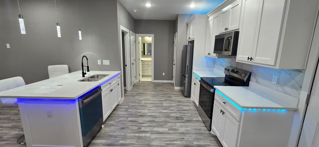 a kitchen that has a lot of cabinets and wooden floor