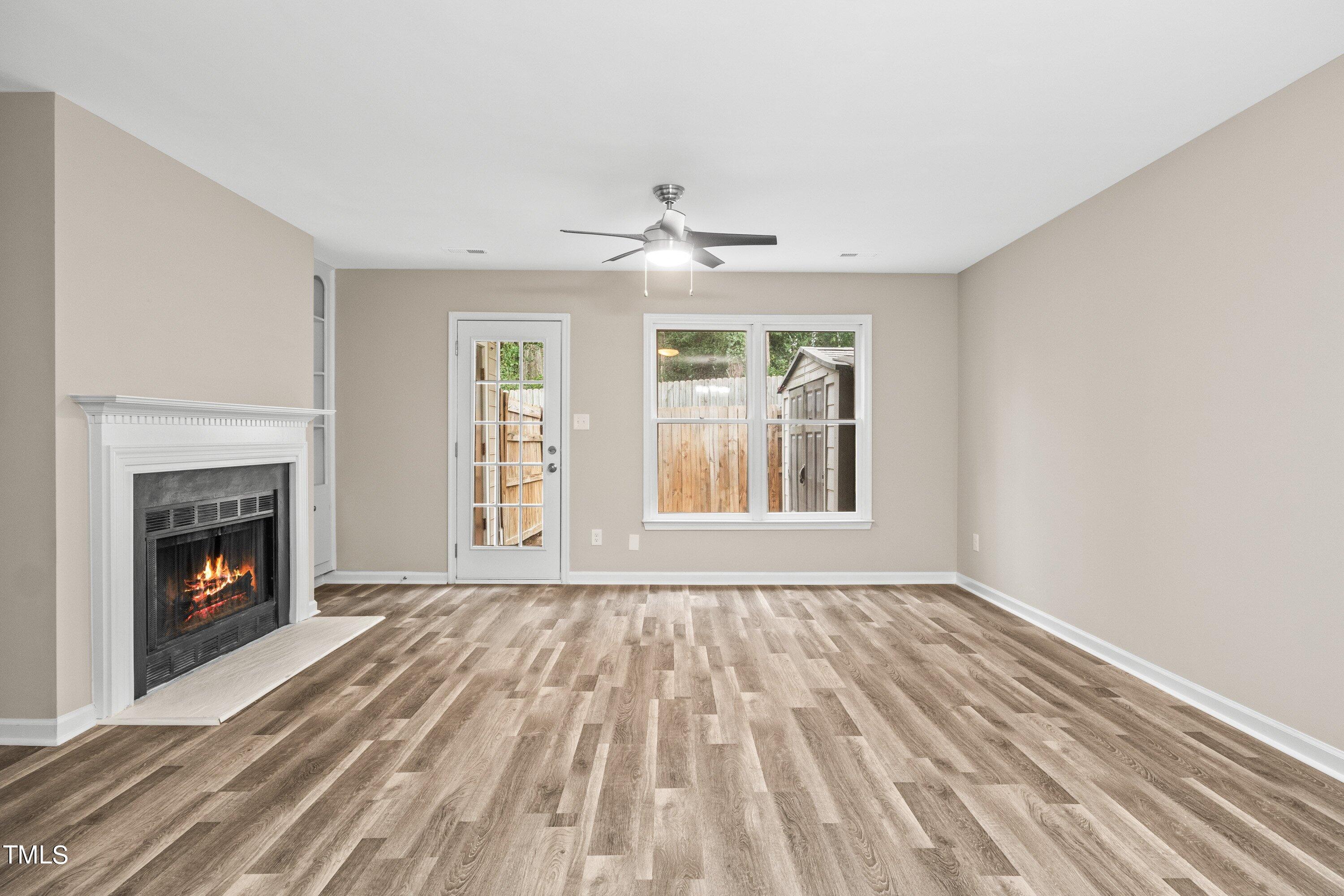 4440 Roller Court Raleigh, NC 27604 - Photo 11 of 38 a view of an empty room with wooden floor fireplace and a window