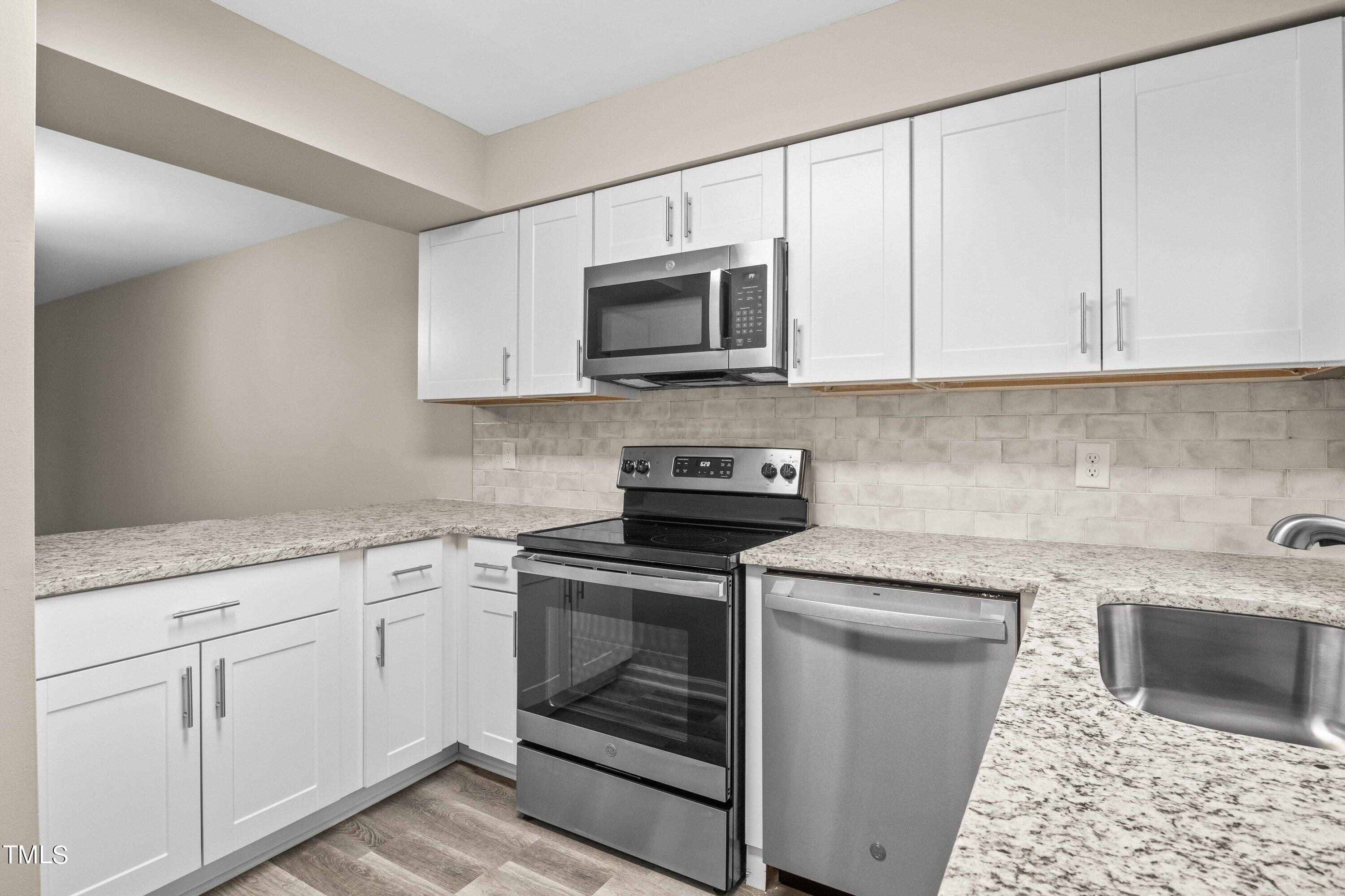 4440 Roller Court Raleigh, NC 27604 - Photo 17 of 38 a kitchen with white cabinets stainless steel appliances and sink
