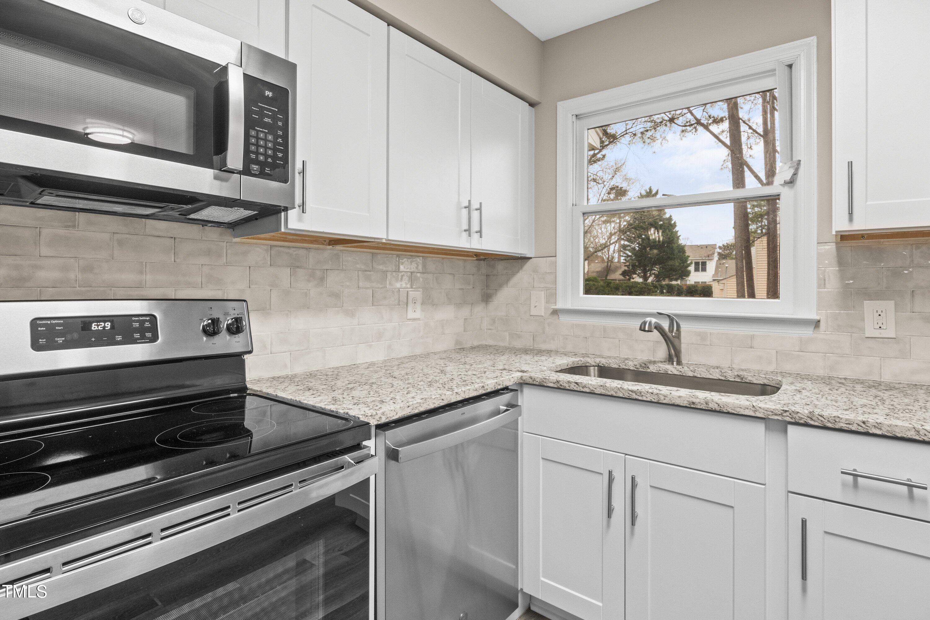 4440 Roller Court Raleigh, NC 27604 - Photo 18 of 38 a kitchen with appliances cabinets and a window