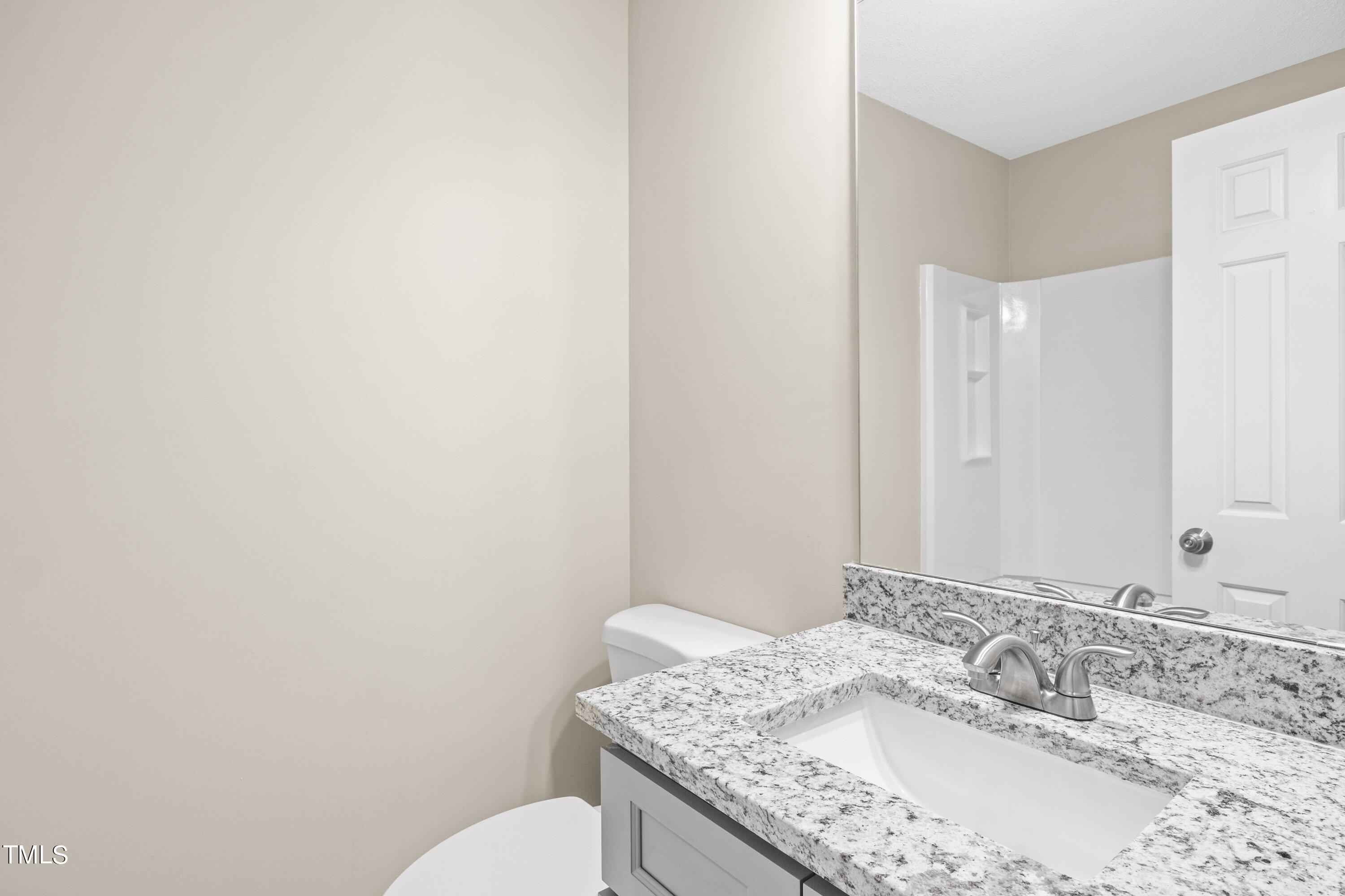 4440 Roller Court Raleigh, NC 27604 - Photo 27 of 38 a bathroom with a granite countertop sink and a mirror