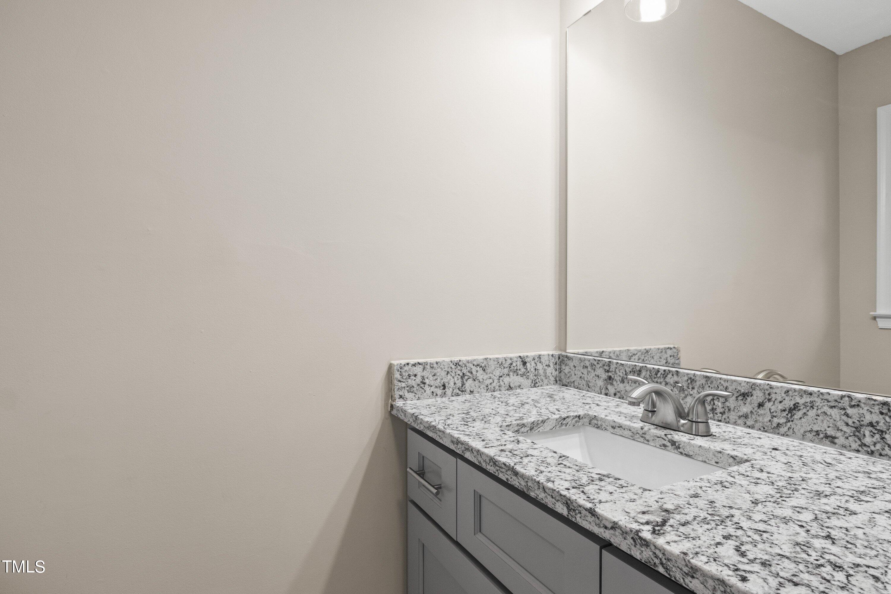 4440 Roller Court Raleigh, NC 27604 - Photo 29 of 38 a bathroom with a granite countertop sink and a mirror