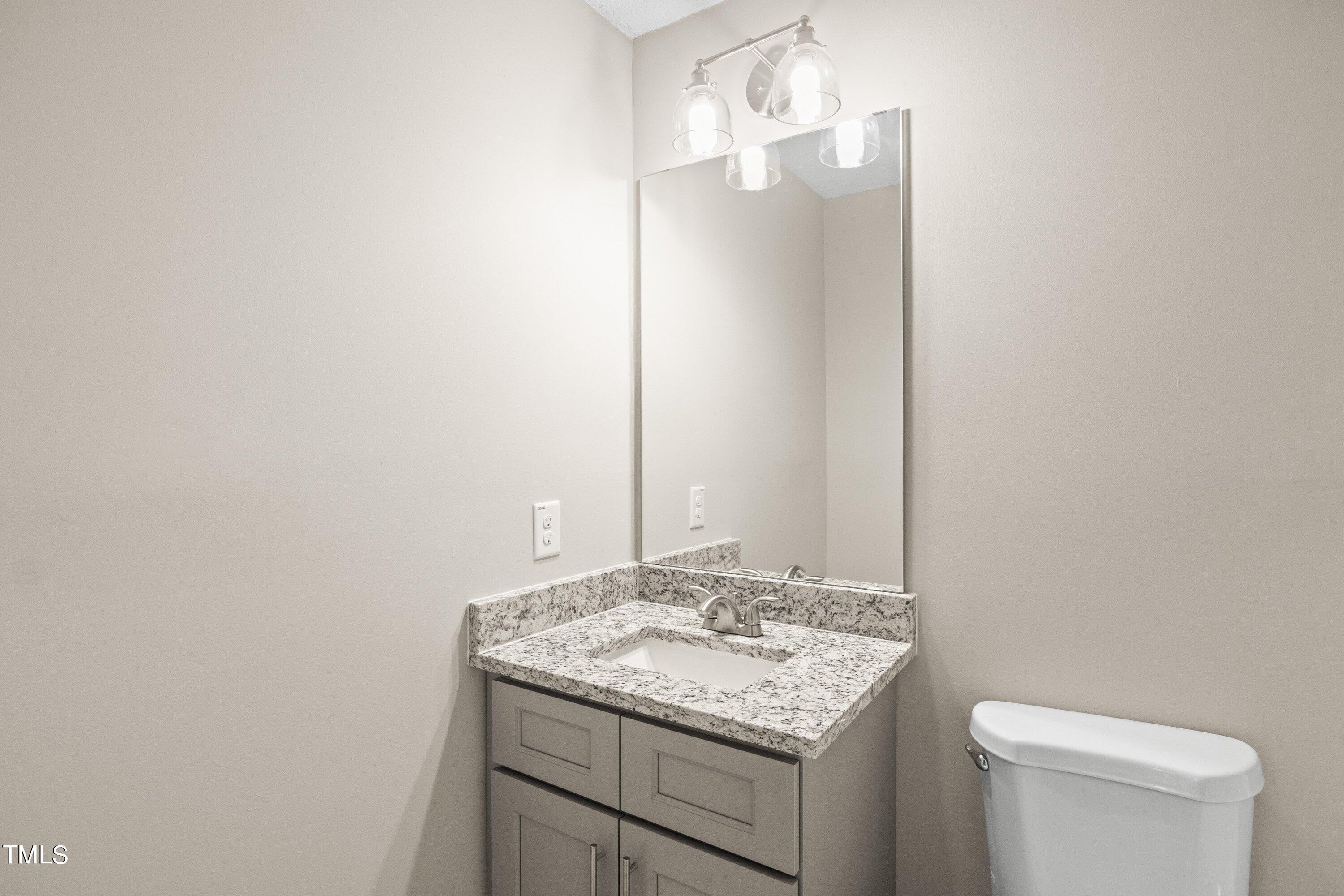 4440 Roller Court Raleigh, NC 27604 - Photo 32 of 38 a bathroom with a granite countertop sink and a toilet