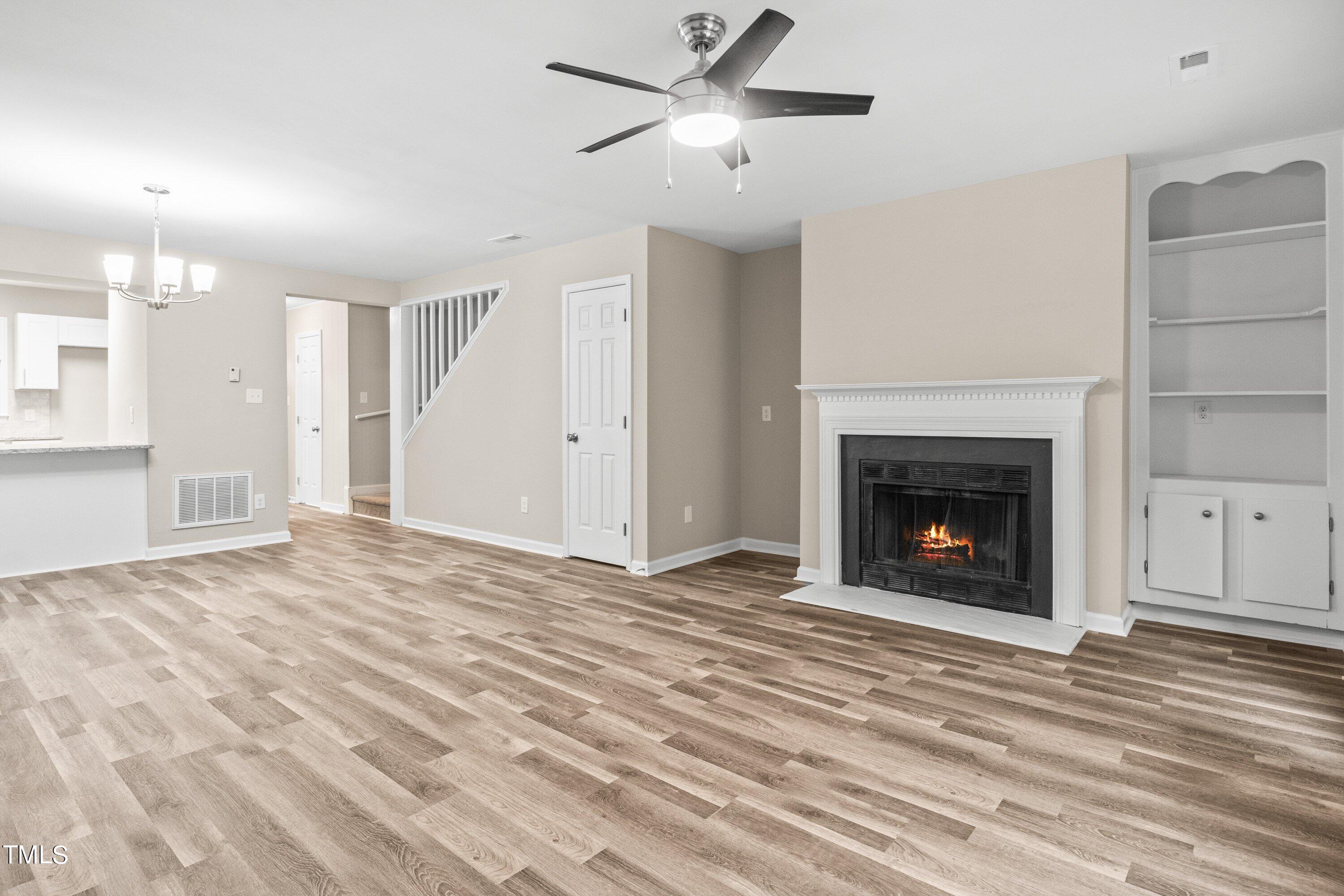 4440 Roller Court Raleigh, NC 27604 - Photo 9 of 38 a view of a livingroom with a fireplace a ceiling fan and fire place